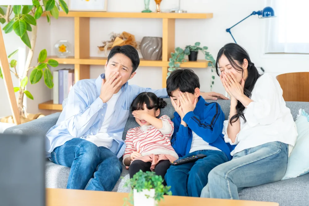 リビングのソファでテレビを見る家族